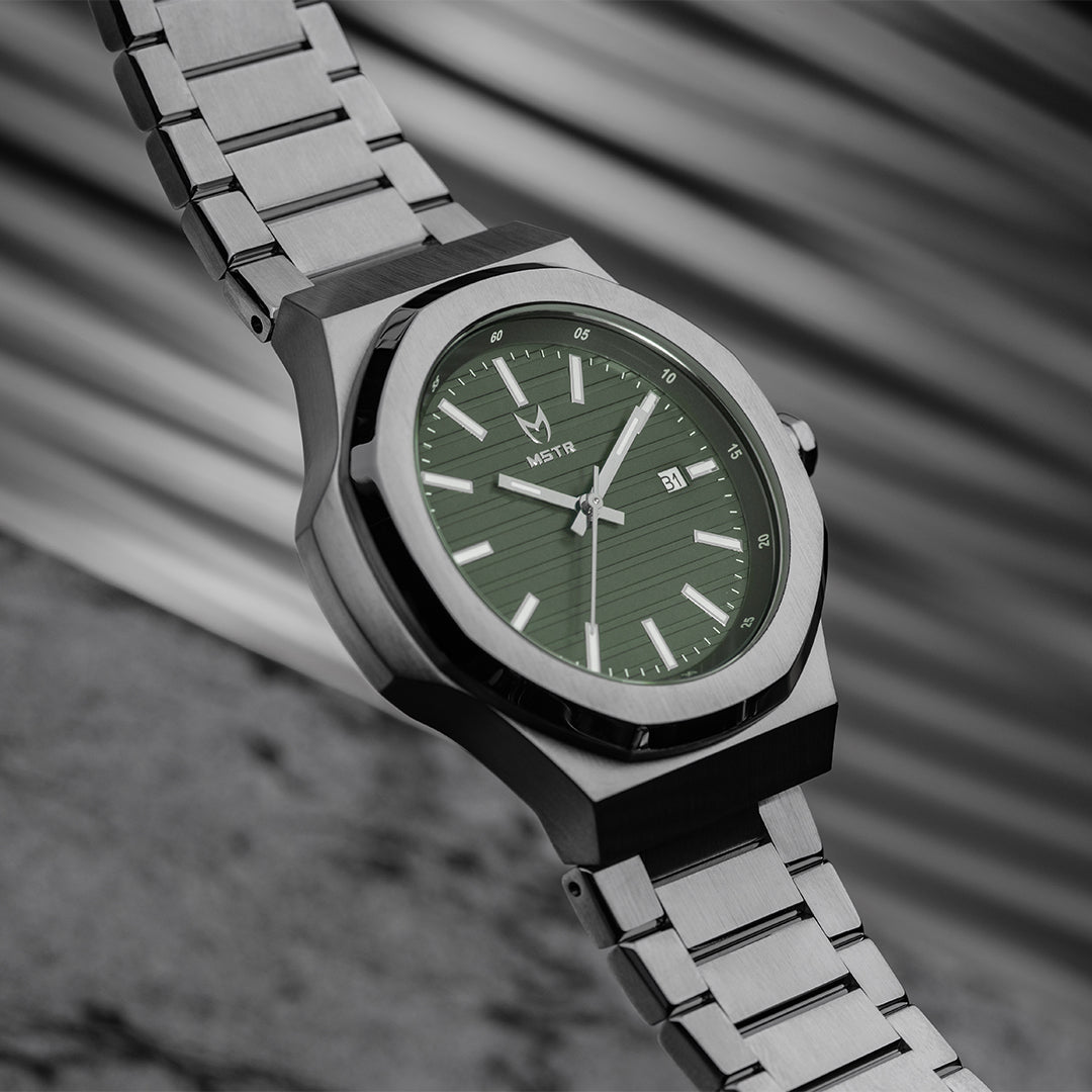 silver watch with green dial